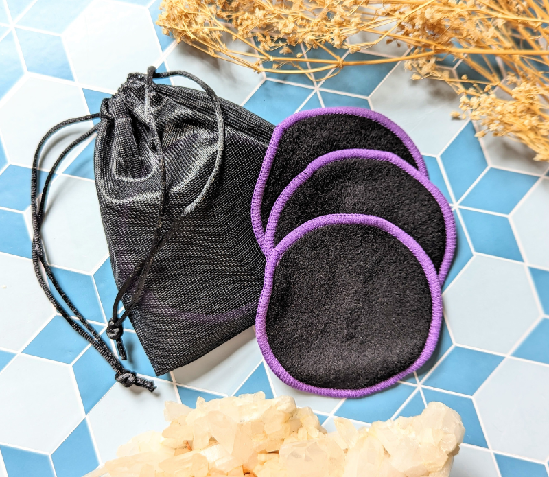 Elevate your makeup routine with this set of 3 machine washable black makeup rounds, elegantly finished with a purple edge. Available at Goddess Provisions